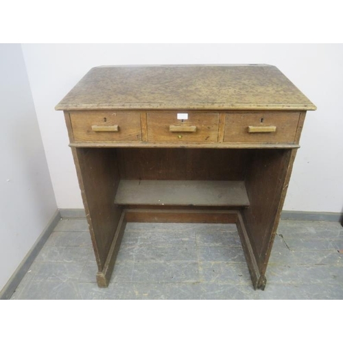 797 - An early 20th century oak schoolmaster’s desk/lectern, having a sloped top above three short drawers... 