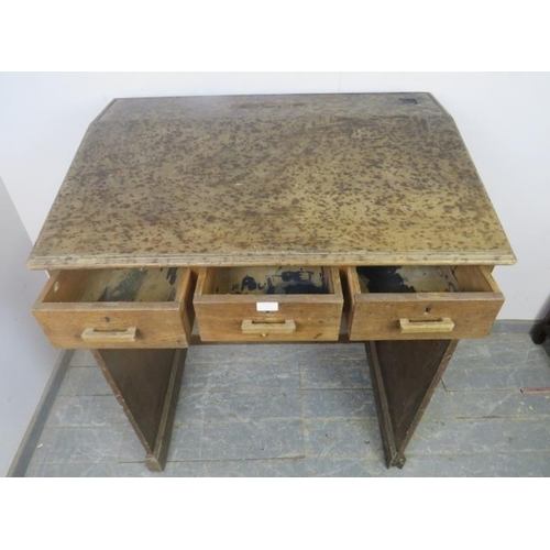 797 - An early 20th century oak schoolmaster’s desk/lectern, having a sloped top above three short drawers... 