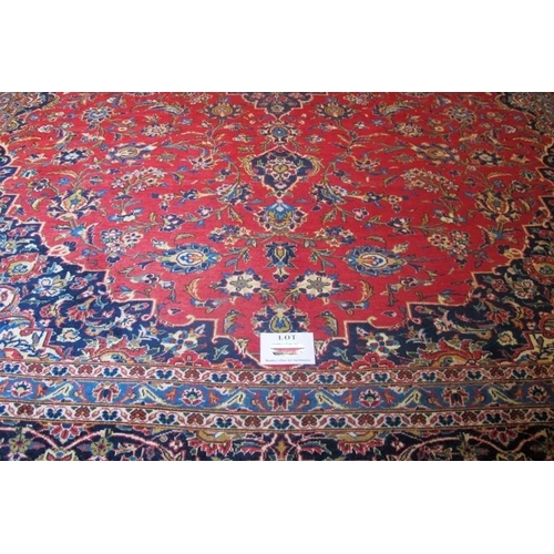 854 - A mid 20th Century Persian Kashan carpet.  Central motif, blue on red ground.  372cm x 283cm approx.... 