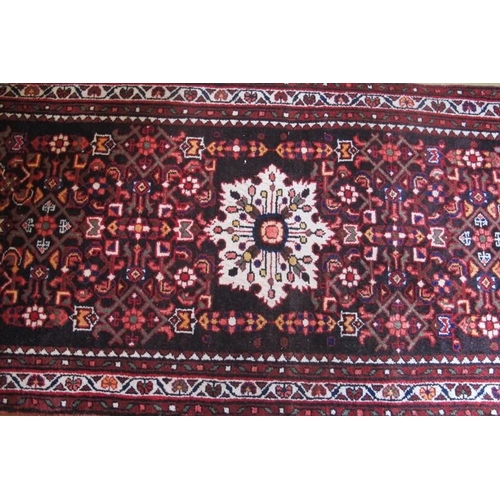 858 - A North West Persian Malayer runner.  A central snowdrop motif in cream on a colourful busy design. ... 