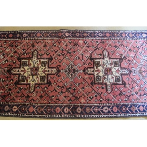 860 - A North West Persian Heriz runner, central repeat motif on salmon ground and in very good condition.... 