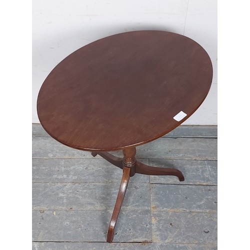 733 - A 19th century oval mahogany tilt-top wine table, on a faux bamboo turned column with delicate tripo... 