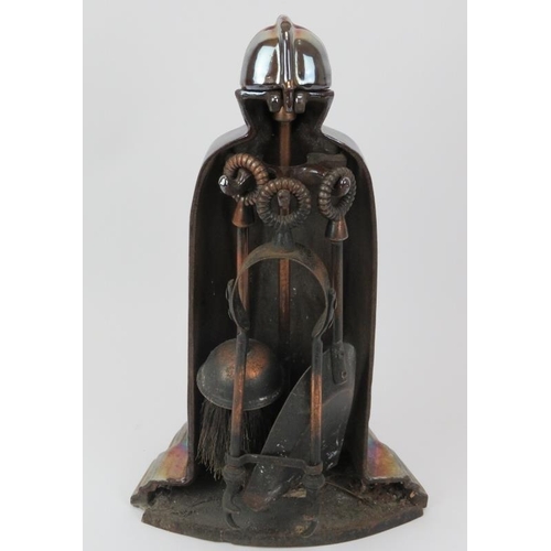 13 - A lustre glazed cast iron fireside companion set modelled as a knight in armour, early 20th century.... 