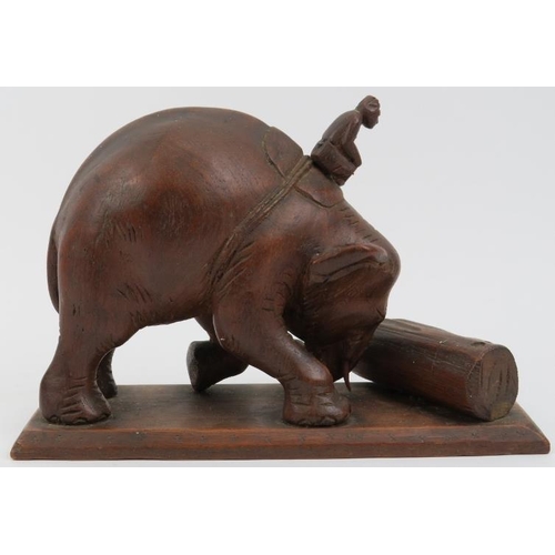 193 - An Indian wood carving of a mahout riding an elephant moving a tree trunk, 20th century. 17.2 cm len... 