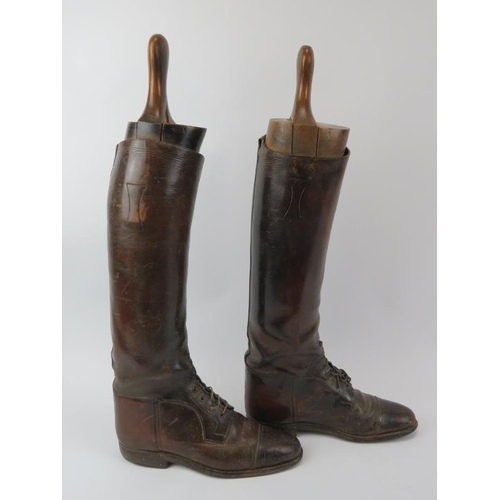 21 - An antique pair of brown leather riding boots with wooden boot trees included. Boots by Huntley & So... 