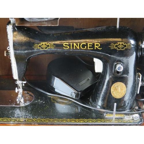 236 - A vintage Singer sewing machine, circa 1945. Painted black with gilt decoration. Mounted on a wooden... 