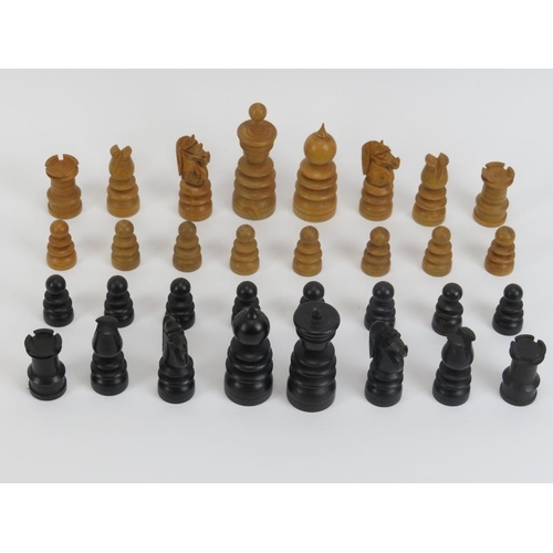 26 - A turned boxwood and ebony chess set, late 19th/early 20th century. Housed in an oak box. (25 items)... 