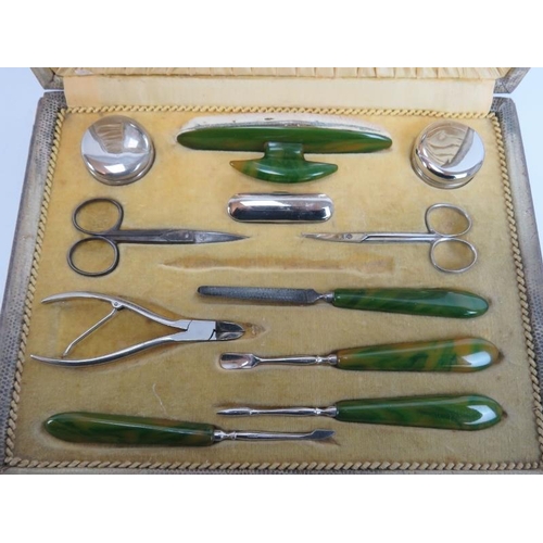 264 - A vintage manicure set with green bakelite handles. Housed in a brown leather case. Case: cm width.
... 