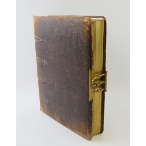 275 - A leather bound Edwardian photo album with gilt spring catch and flower decorated pages. 30cm x 23cm... 