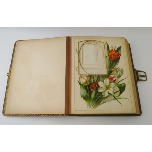 275 - A leather bound Edwardian photo album with gilt spring catch and flower decorated pages. 30cm x 23cm... 