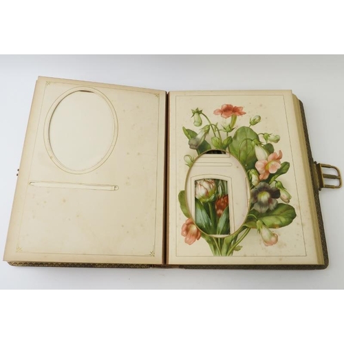 275 - A leather bound Edwardian photo album with gilt spring catch and flower decorated pages. 30cm x 23cm... 