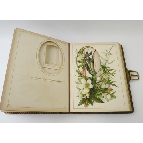 275 - A leather bound Edwardian photo album with gilt spring catch and flower decorated pages. 30cm x 23cm... 