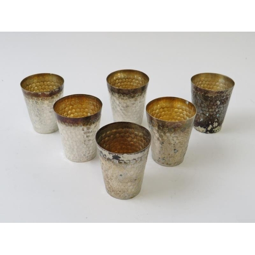 398 - A set of six Chinese hammered white metal tot beakers, each bearing marks to base, height 4cm, and a... 