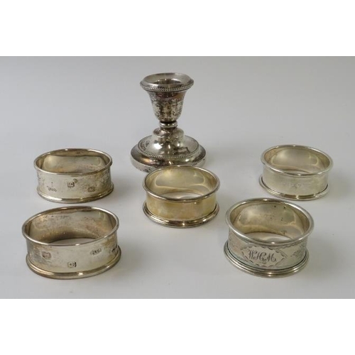 406 - Five silver napkin rings of various design and a silver stub candlestick with weighted base. Various... 