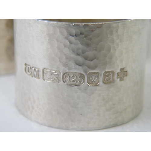 411 - A set of six modernist planished silver napkin rings bearing 2000 Millennium London hallmarks, maker... 