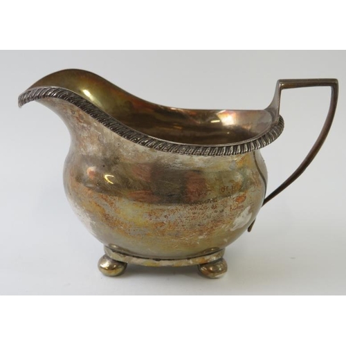 414 - A late 19th century Georgian revival silver cream jug with gadrooned rim and ball feet. Hallmarked f... 