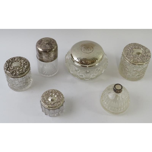 423 - Five antique silver topped cut glass vanity jars of various form and a silver collared perfume bottl... 