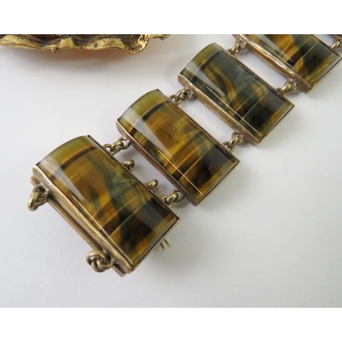 469 - A precious yellow metal and tiger’s eye and panel bracelet stamped 9CT; and a large banded agate pin... 