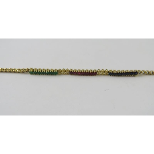 487 - A pretty tennis style bracelet with panels of emeralds, rubies and sapphires inter set with diamonds... 