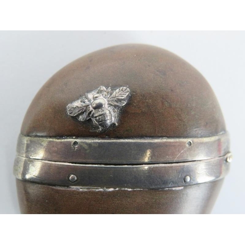 95 - A coquilla nut vesta case, 19th century. White metal mounted and applied with a honey bee in relief.... 