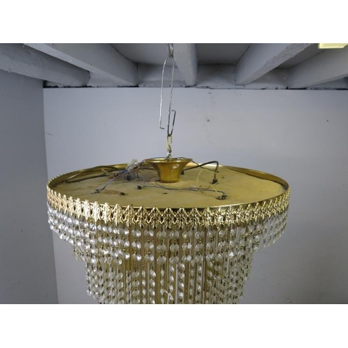 702 - An antique style brass and crystal seven tier waterfall chandelier. Total drop is 75cm. Accepts five... 