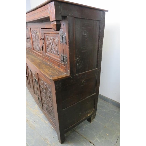 705 - A 17th century oak court cupboard of small proportions, having inverted finials above three cupboard... 