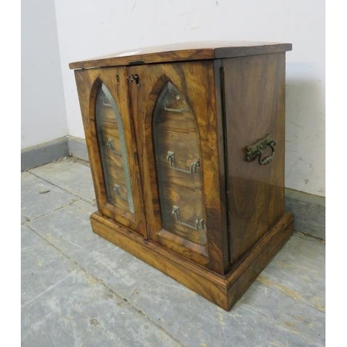 708 - A Victorian figured walnut humidor, the doors with bevelled glass panels in the form of Gothic arche... 