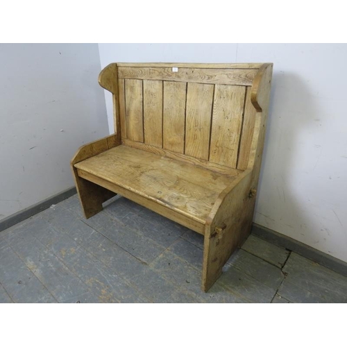 715 - An antique elm settle of small proportions, the panelled back above a planked seat, on stile support... 