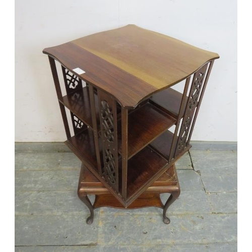 718 - An Edwardian mahogany revolving book table, the shaped top above pierced fretwork side panels and op... 