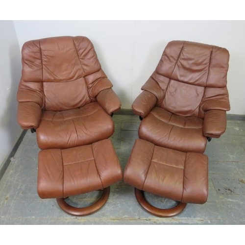 730 - A pair of brown leather ‘Stressless’ reclining lounge chairs by Ekornes, on swivelling circular plin... 