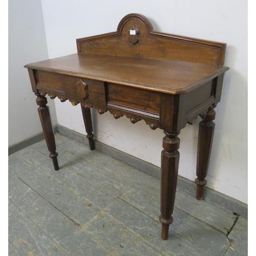 744 - A Victorian medium oak hall table, the shaped gallery with central carved shield decoration, housing... 