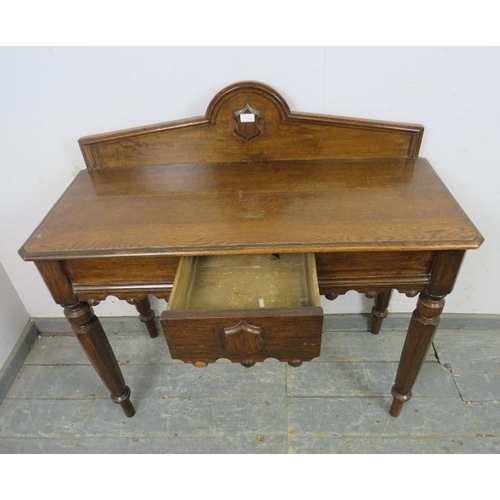 744 - A Victorian medium oak hall table, the shaped gallery with central carved shield decoration, housing... 