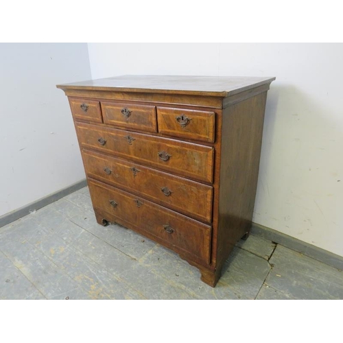 747 - An 18th century figured walnut chest, housing three short above three long graduated drawers with in... 