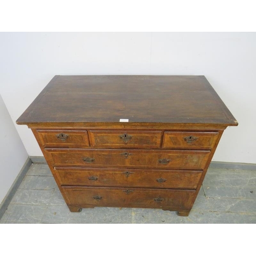 747 - An 18th century figured walnut chest, housing three short above three long graduated drawers with in... 