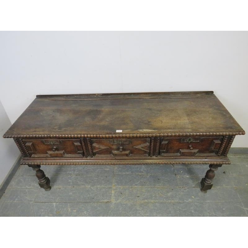 749 - A 17th century Charles II and later oak dresser base, housing three short drawers with block geometr... 