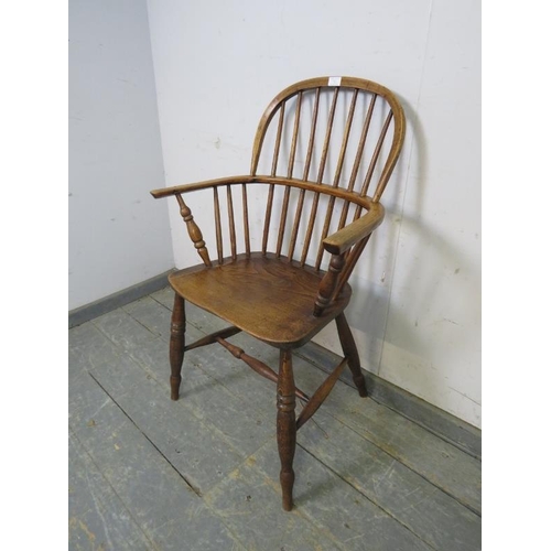 751 - A 19th century elm hoop-back Windsor chair, on turned supports joined with a turned ‘H’ stretcher. 
... 