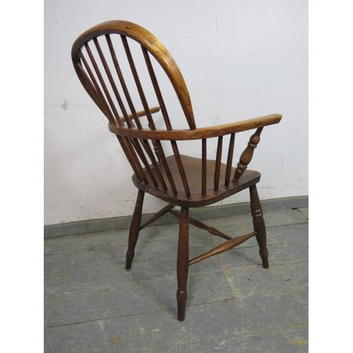 751 - A 19th century elm hoop-back Windsor chair, on turned supports joined with a turned ‘H’ stretcher. 
... 