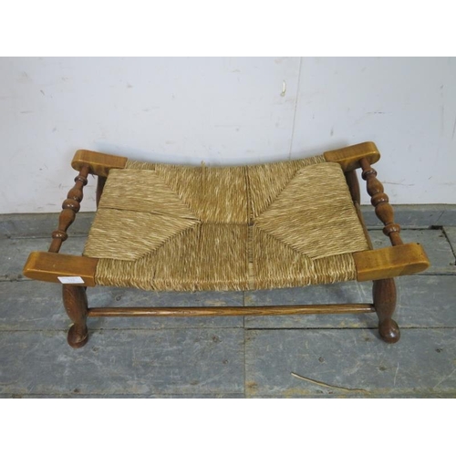 752 - An antique Arts & Crafts Period oak footstool, the curved rush seat on turned supports joined with s... 