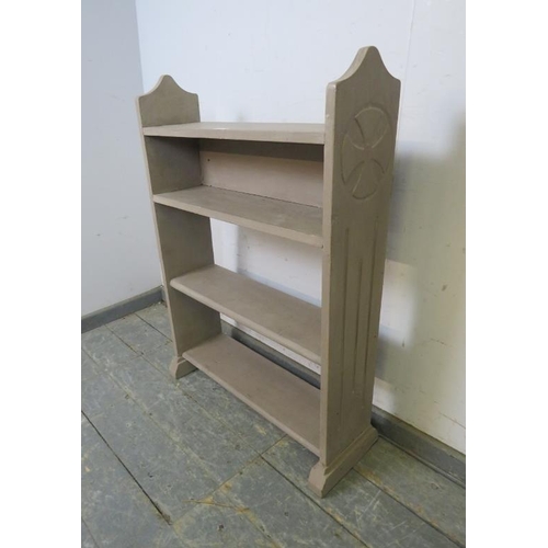 757 - An antique pine open bookcase of four shelves, painted grey, the shaped sides with relief carved Kni... 