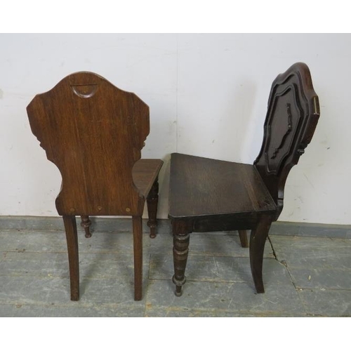 763 - A pair of Victorian oak hall chairs, the shaped backs with relief carved decoration, on tapered turn... 