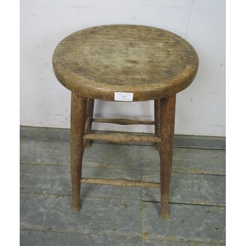 767 - An antique elm artist’s stool, the dished oval top on tapered supports with pad feet, joined by doub... 