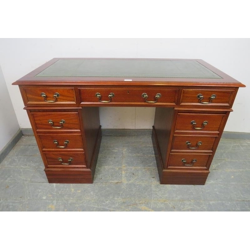 768 - An antique style reproduction mahogany pedestal desk, the top with inset green leather surface, hous... 