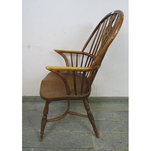 773 - A vintage elm hoop-back Windsor chair in the 19th century style, with shaped and pierced splat, on t... 