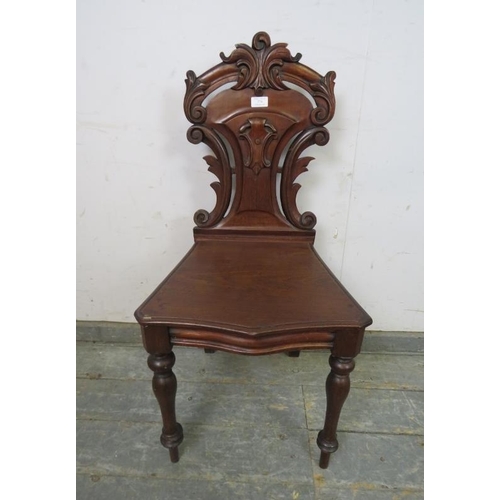 774 - A 19th century mahogany hall chair, the carved and pierced back modelled as scrolling acanthus leave... 