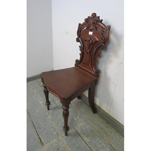 774 - A 19th century mahogany hall chair, the carved and pierced back modelled as scrolling acanthus leave... 