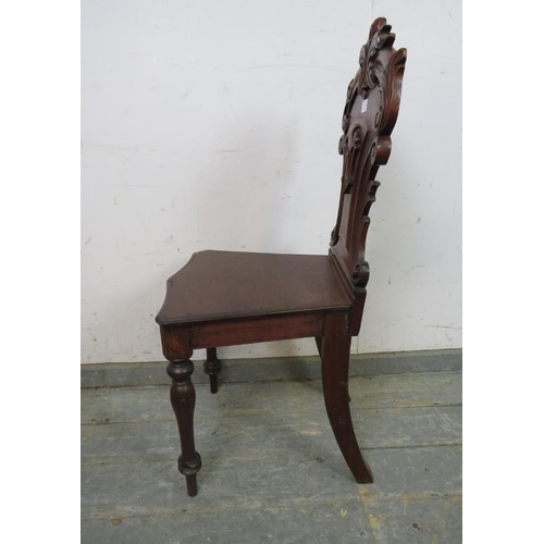 774 - A 19th century mahogany hall chair, the carved and pierced back modelled as scrolling acanthus leave... 