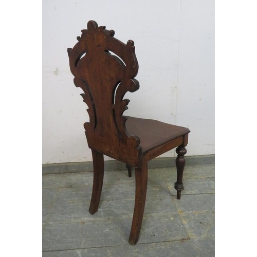 774 - A 19th century mahogany hall chair, the carved and pierced back modelled as scrolling acanthus leave... 