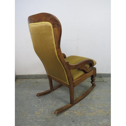 775 - A Victorian walnut rocking chair, re-covered in buttoned tan material, on turned supports with rocke... 