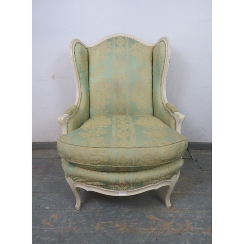 803 - An antique French giltwood wingback armchair, upholstered in pistachio green damask material, on cab... 