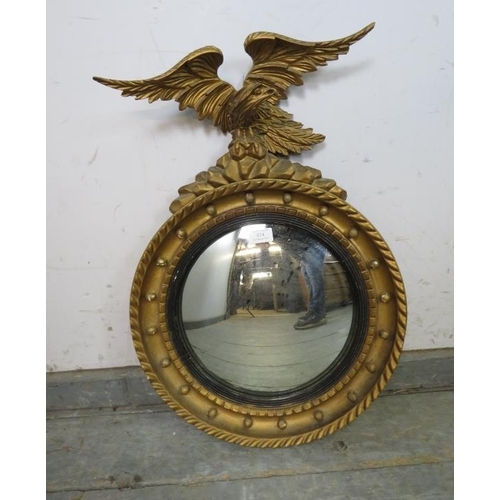 814 - An antique convex mirror in the Regency taste, the reeded ebonised border within a gilt frame with a... 